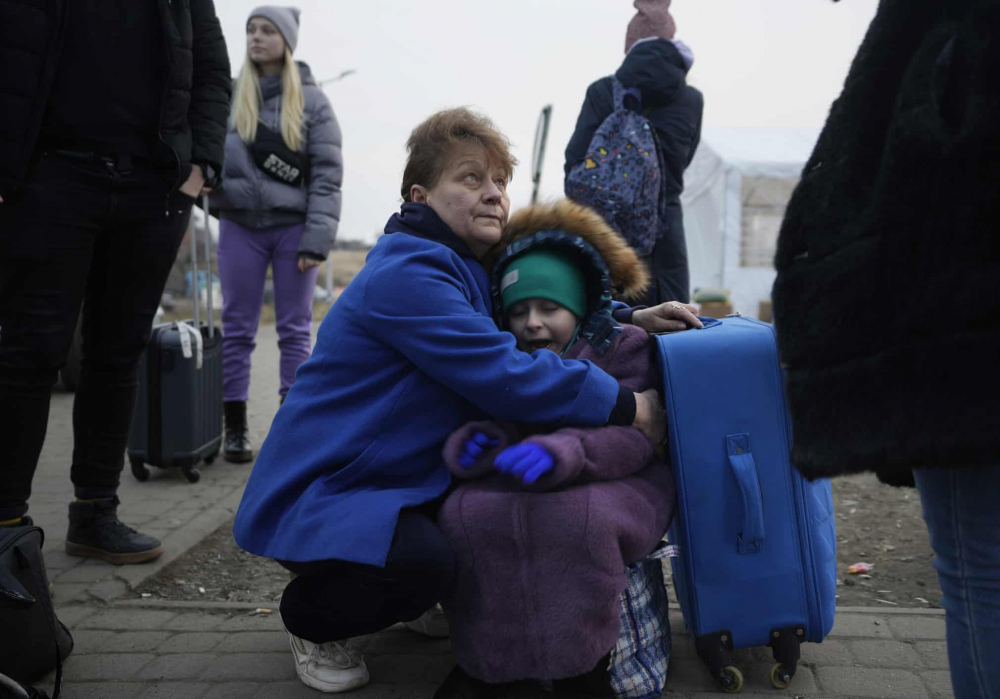 Một người phụ nữ ôm cháu gái khi họ chờ đợi tại cửa khẩu biên giới ở Medyka, Ba Lan