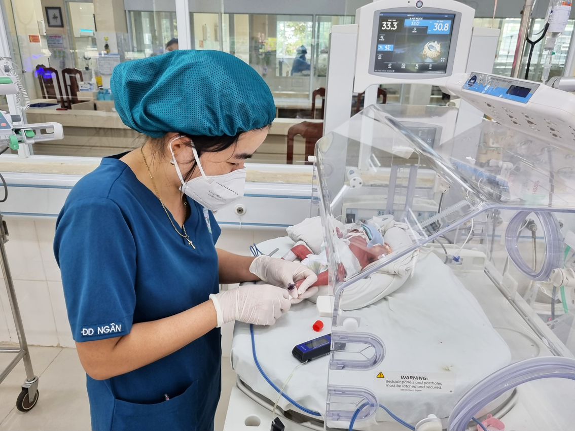 Do có nhiều trẻ bị bỏ rơi nên công việc của các nữ điều dưỡng ở Bệnh viện Nhi Đồng Nai càng thêm vất vả. (Trong ảnh: Nữ điều dưỡng ở Bệnh viện Nhi Đồng Nai đang theo dõi sức khỏe trẻ sơ sinh) - ẢNH: G.H.