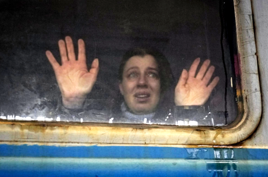 Một người phụ nữ trên một đoàn tàu tại sân ga ở Kiev, Ukraine đang nhìn về phía người thân - ẢNH: AP