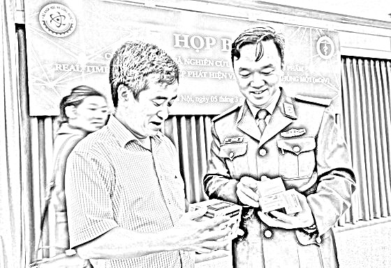 Thượng tá Hồ Anh Sơn, chủ nhiệm đề tài (phải), cùng bị can Phan Quốc Việt (Chủ tịch kiêm Tổng giám đốc Công ty Việt Á) giới thiệu bộ kit test COVID-19 - Ảnh: VGP