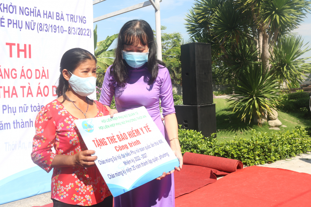 Bà Nguyễn Thị Thu Hà - Chủ tịch Hội LHPN phường Thới An - trao bảng tượng trưng tặng thẻ bảo hiểm y tế cho phụ nữ có hoàn cảnh đặc biệt khó khăn. 