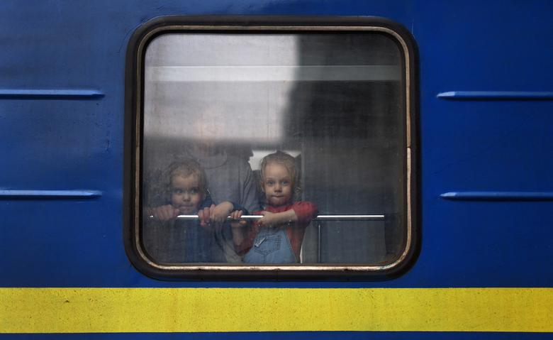 Trẻ em nhìn ra cửa sổ xe lửa trong khi chờ đợi chuyến khởi hành đến Ba Lan tại nhà ga xe lửa ở Lviv, Ukraine. Các tổ chức nhân đạo đang tích cực sơ tán trẻ em Ukraine đến các nước láng giềng an toàn trong những ngày qua.