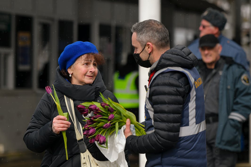 Lính biên phòng Rumani tặng hoa cho một người phụ nữ tị nạn từ Ukraine nhân ngày Quốc tế Phụ nữ 8/3 - Ảnh: Andreea Alexandru/AP