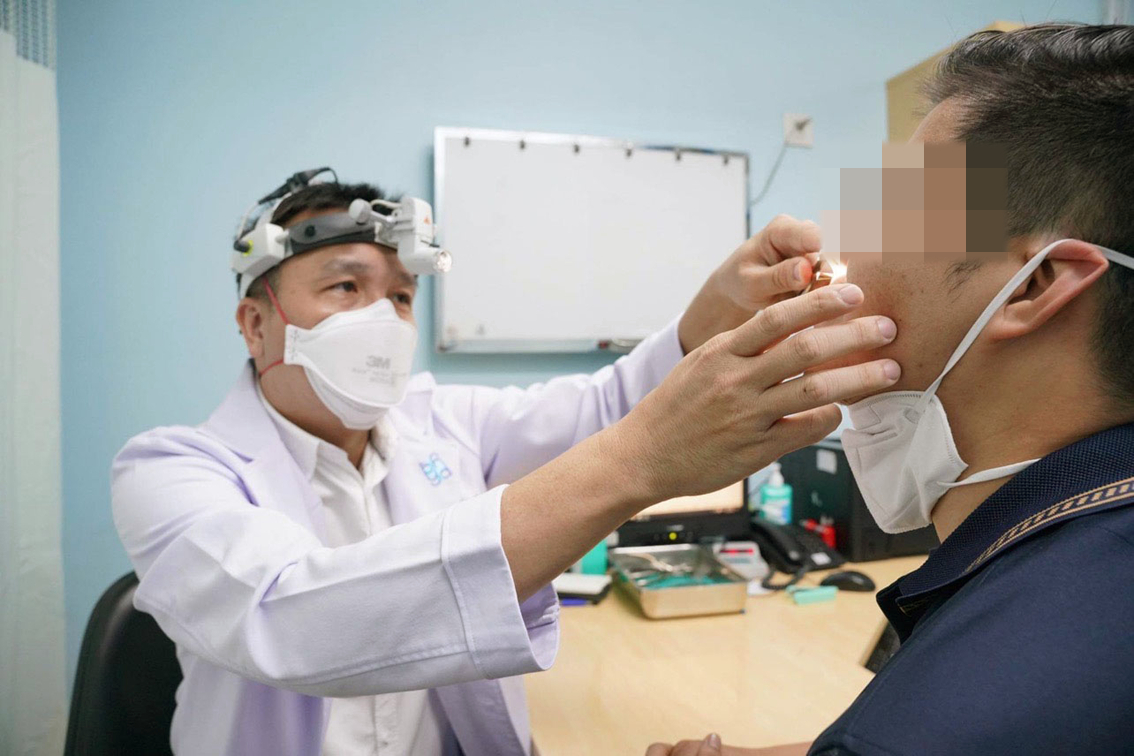 Bác sĩ Lý Xuân Quang đang khám cho một bệnh nhân bị biến chứng do lạm dụng thuốc co mạch gây phù nề, bít tắc hốc mũi