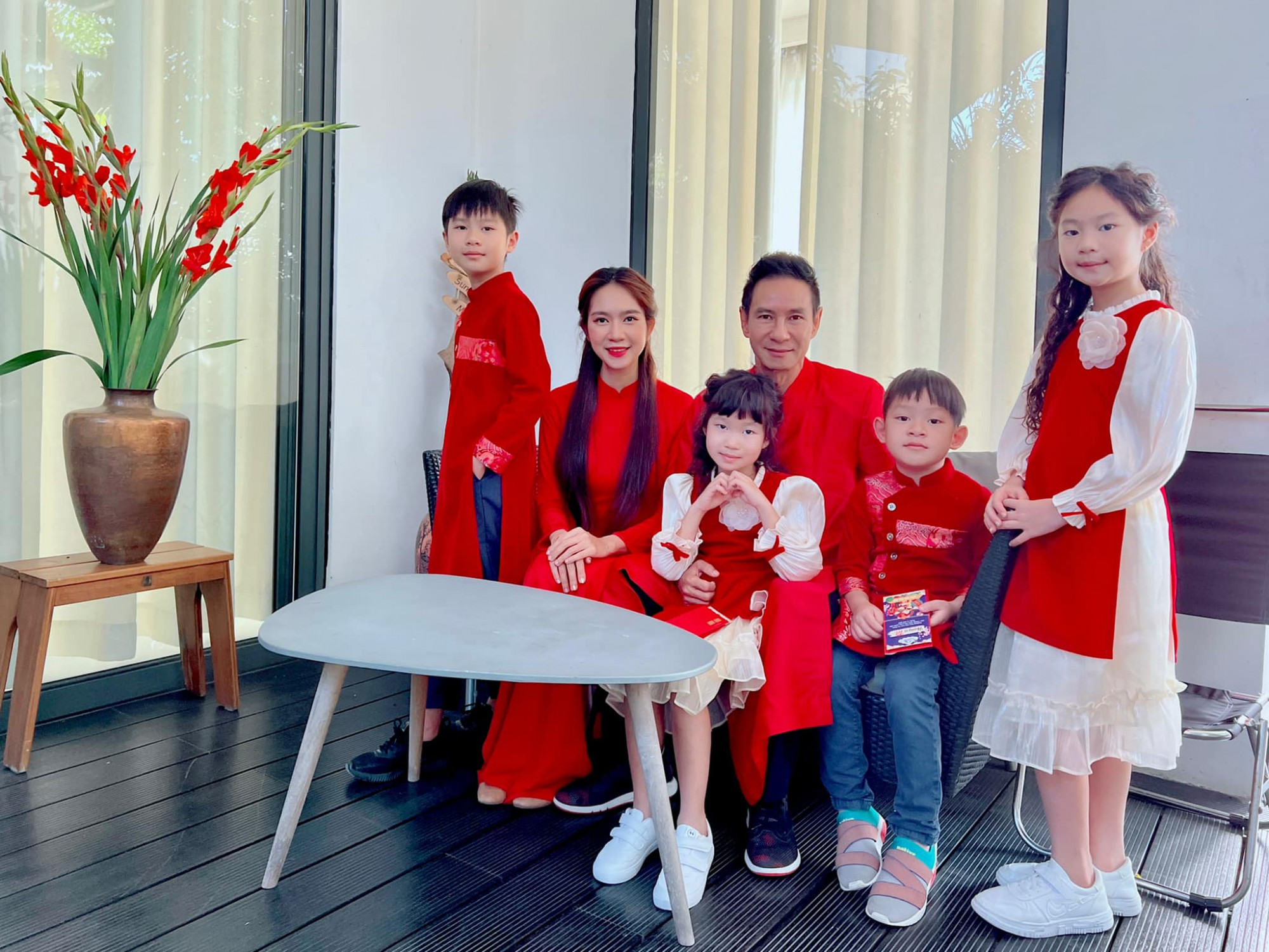 Các thành viên trong gia đình ca sĩ Lý Hải diện áo dài đồng điệu sắc đỏ.