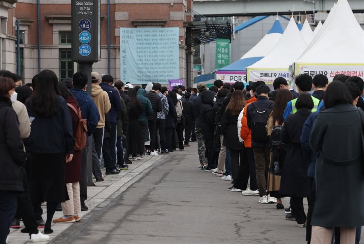 Mọi người xếp hàng chờ nhận xét nghiệm COVID-19 tại một trung tâm gần Ga Seoul, 