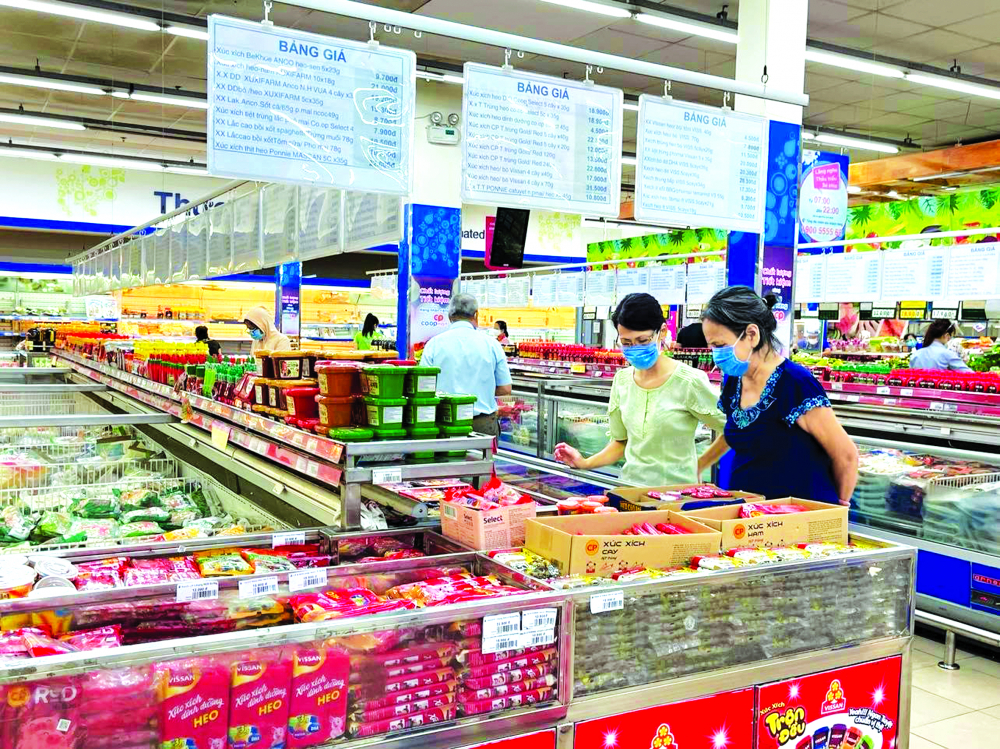 Người tiêu dùng phân vân khi lựa chọn thực phẩm vì phải thắt chặt chi tiêu trước cơn “bão giá” ẢNH: NGUYỄN CẨM