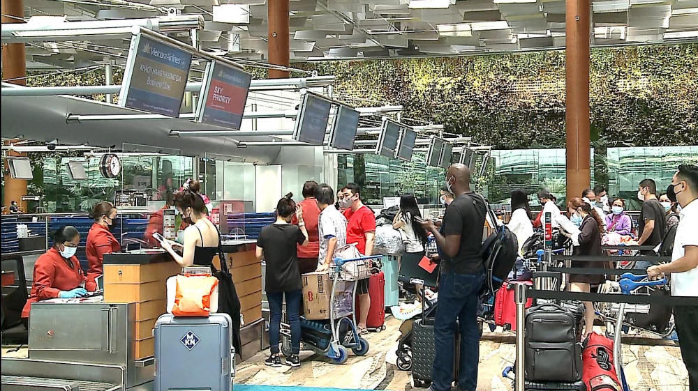 Du khách làm thủ tục tại sân bay Singapore trước giờ khởi hành về Việt Nam