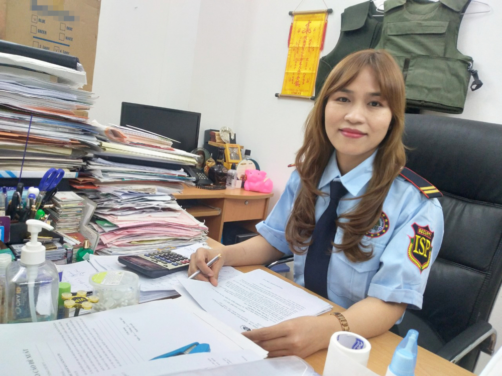 Nữ vệ sĩ Trần Thị Mý đang xem lại một hợp đồng