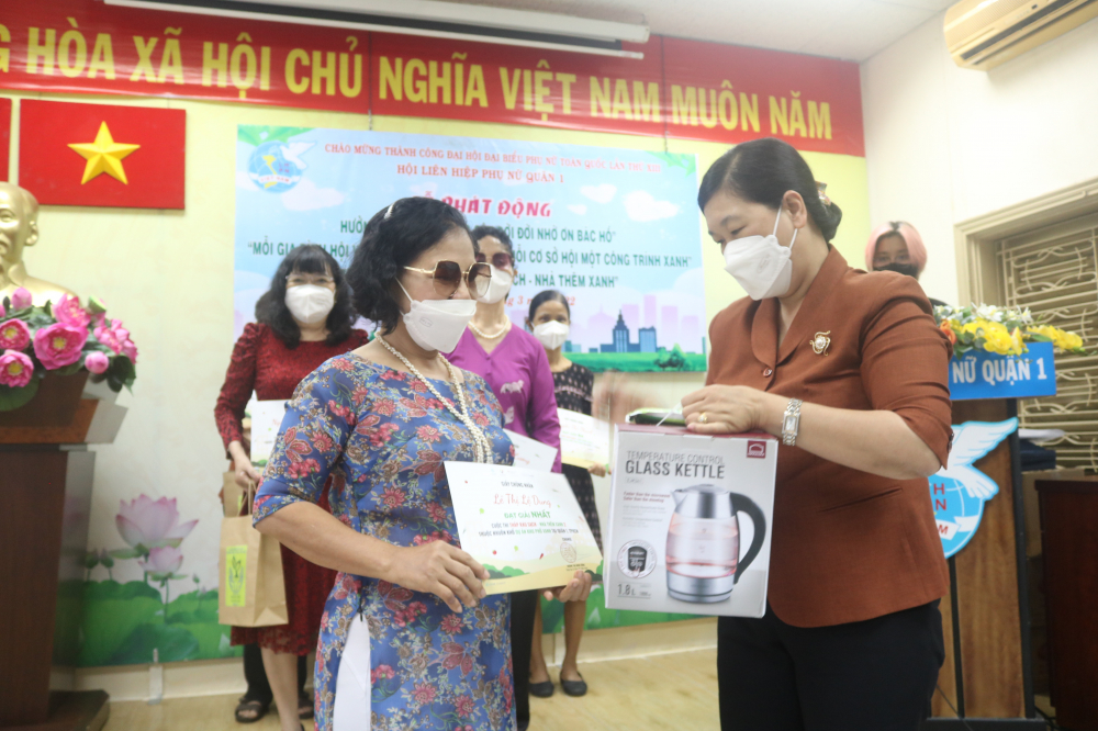 Bà Hoàng Thị Tố Nga (bìa phải) - Phó bí thư Quận ủy quận 1 - trao giải nhất cuộc thi Tháp rau sạch - Nhà thêm xanh cho dì Lệ Dung. 