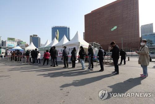 Người dân xếp hàng chờ xét nghiệm COVID-19 tại Seoul, Hàn Quốc.
