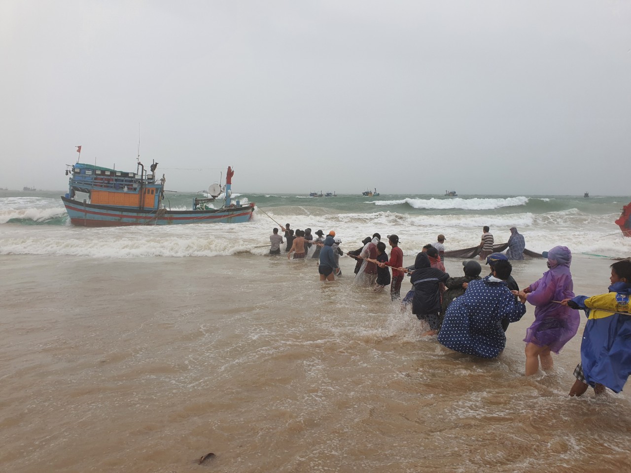 Người dân cứu tàu thuyền bị sóng biển đánh chìm