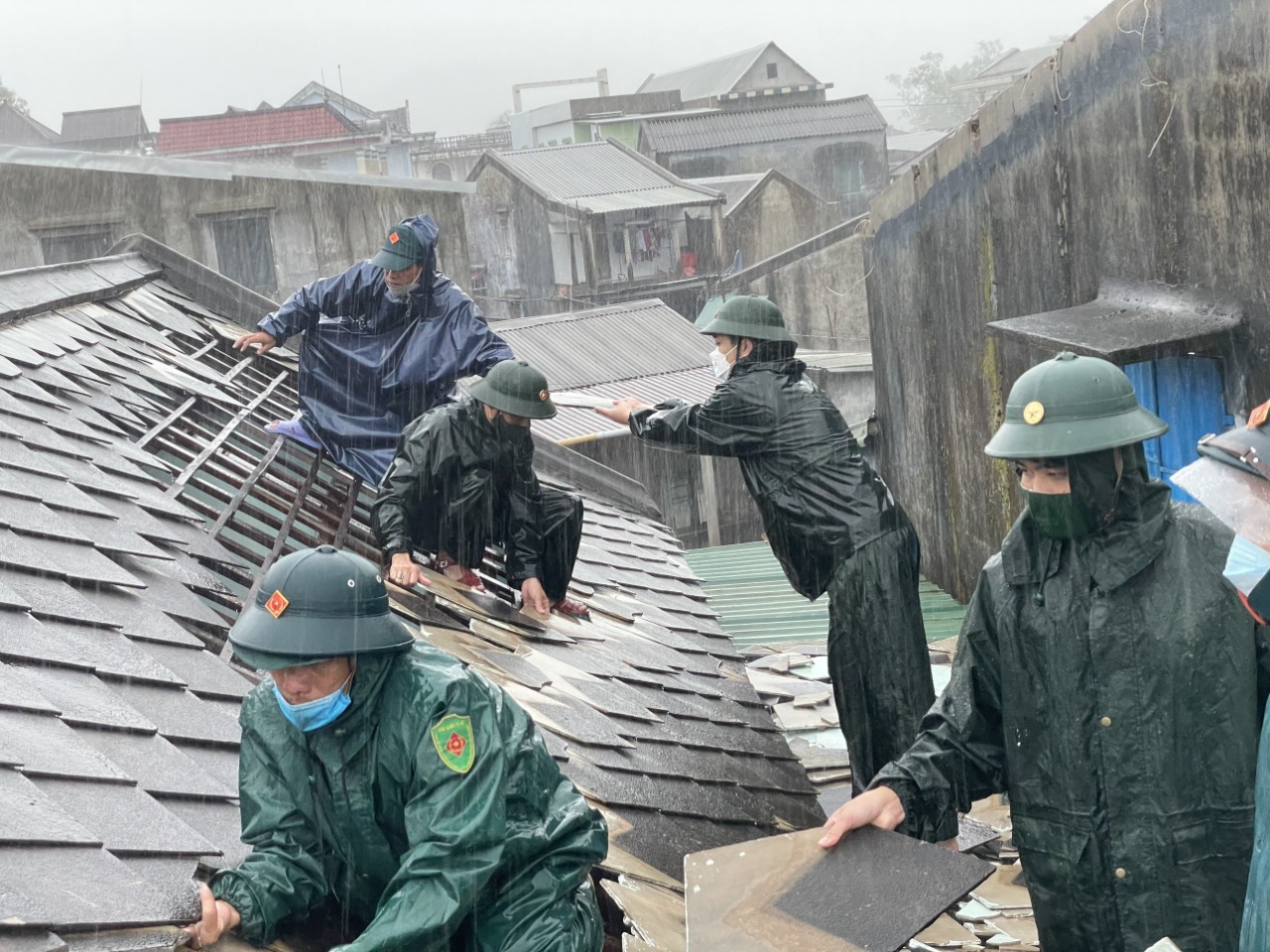 Bộ đội giúp dân lợp lại mái nhà bị tốc mái ở xã Vinh Hiền