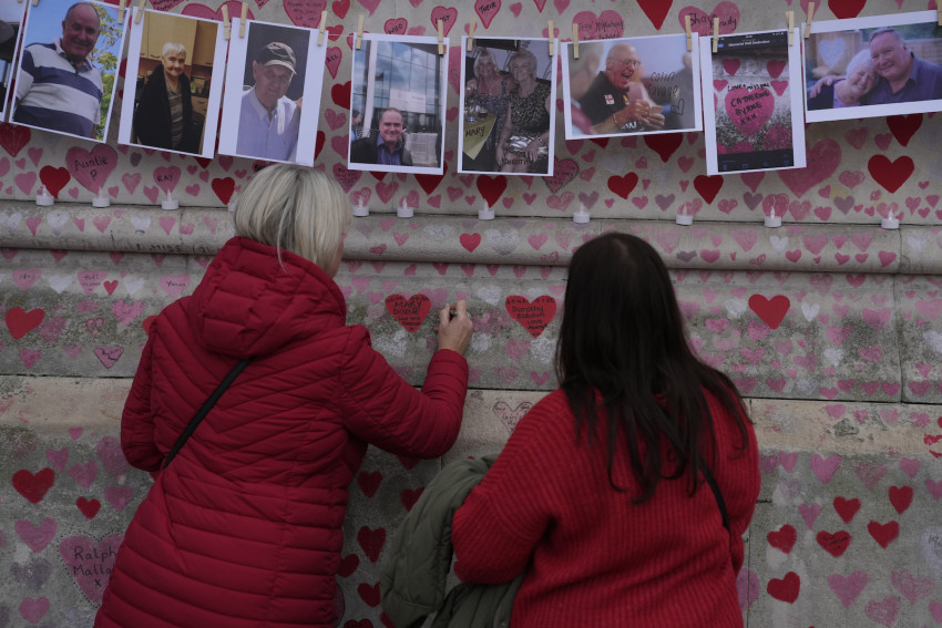 Các thành viên trong gia đình viết lời nhắn cho hai chị em gái đã chết vì COVID trên bức tường National Covid Memorial ở London.