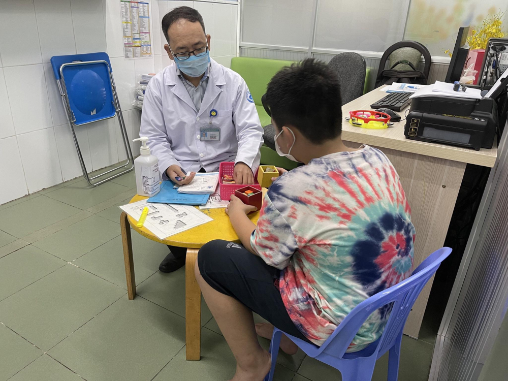 Bác sĩ Đinh Thạc đang điều trị tâm lý cho trẻ - Ảnh: Thanh Huyền 