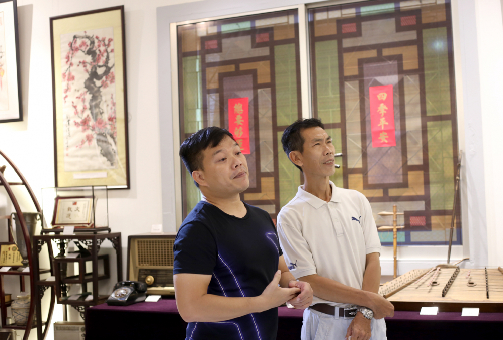 Anh Dương Rạch Sanh (bên trái) và họa sĩ Trần Văn Hải trao đổi về các cổ vật