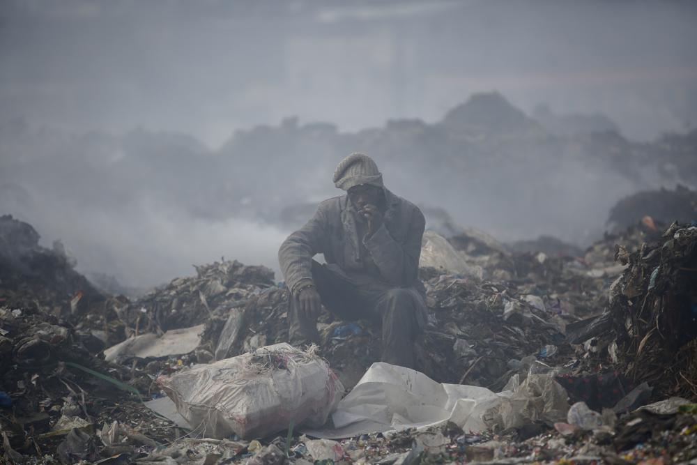 Một người đàn ông nhặt rác để kiếm sống đang nghỉ ngơi tại bãi rác lớn nhất ở thủ đô Nairobi, Kenya