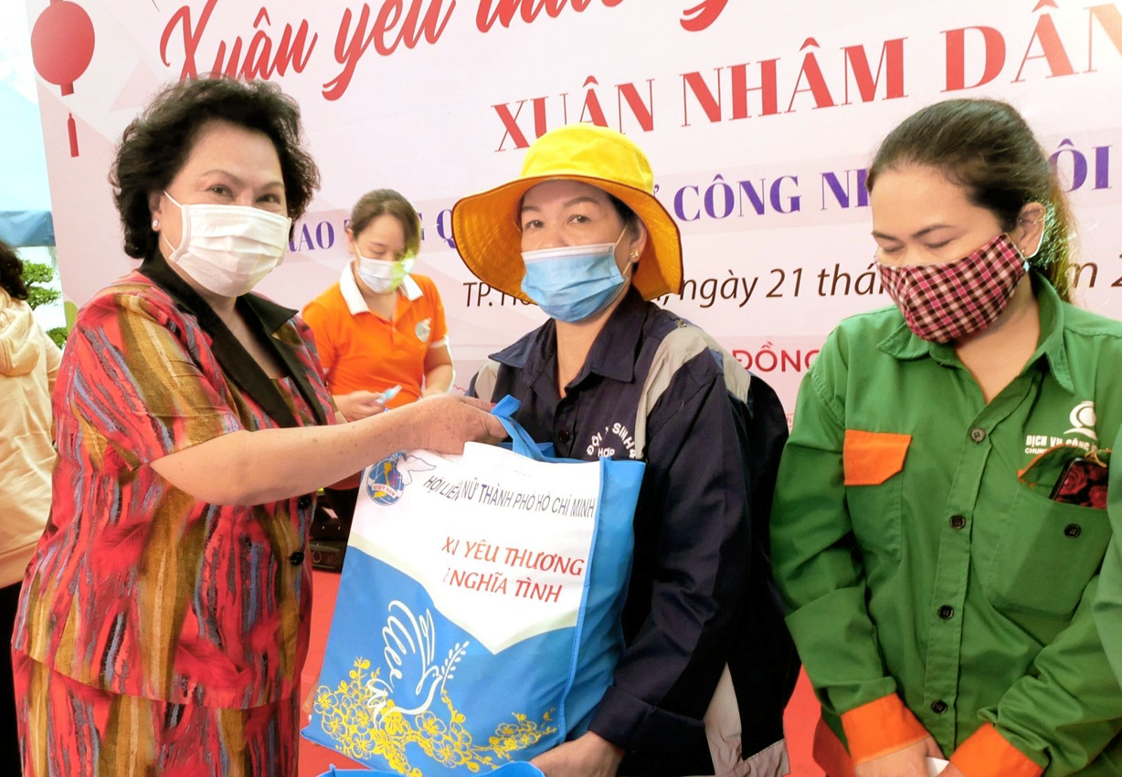 Bà Lý Kim Chi (bìa trái) tặng quà cho nữ công nhân môi trường gặp khó khăn do dịch COVID-19 - Ảnh: Diễm Trang