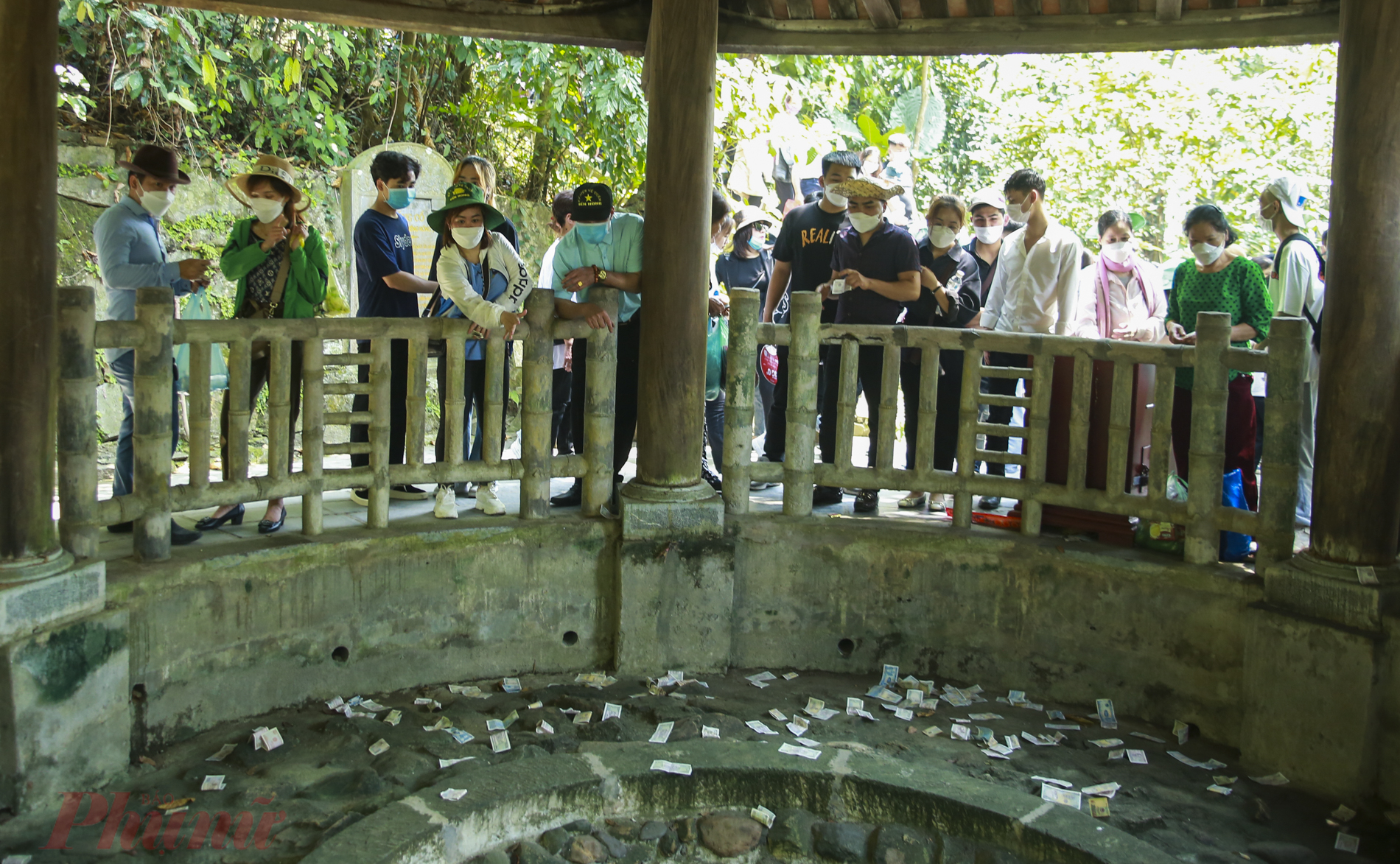  Người dân đua nhau thả tiền xuống giếng cổ phớt lờ biển báo quy định tại trong khu di tích Đền Hùng, Phú Thọ.
