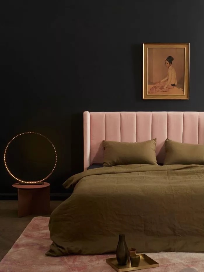 Sự kết hợp tưởng như không thể của bức tường sơn đen và phần trang trí đầu giường màu hồng vừa giúp giảm cám giác kinh dị vừa giúp bạn cảm thấy thư giãn, thoải mái hơn. 