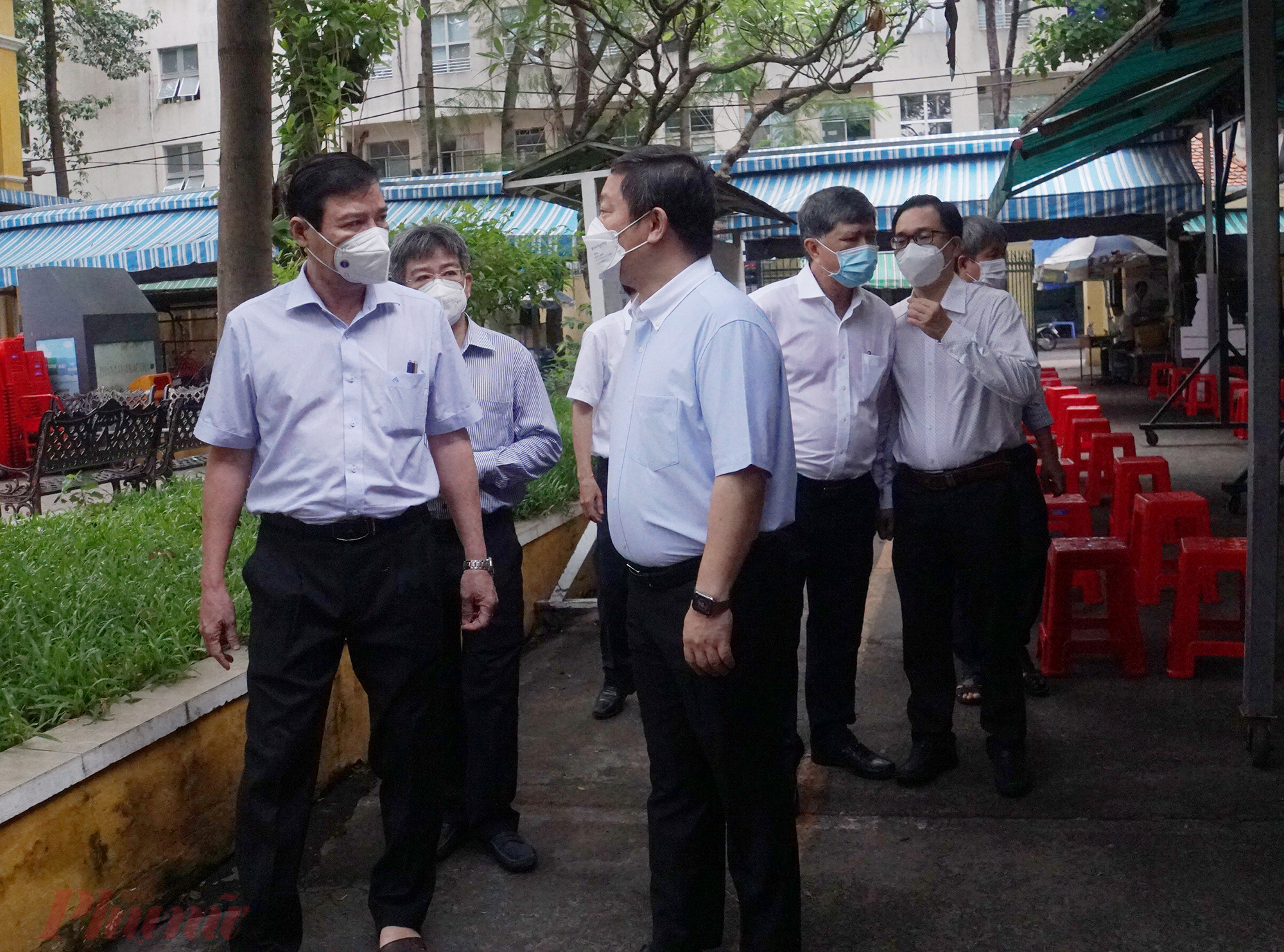 Ông Dương Anh Đức - Phó Chủ tịch UBND TPHCM (hàng đầu, bên phải) cùng Phó Giám đốc Sở Y tế Nguyễn Hữu Hưng khảo sát điểm tiêm trường THCS Hồng Bàng (quận 5)