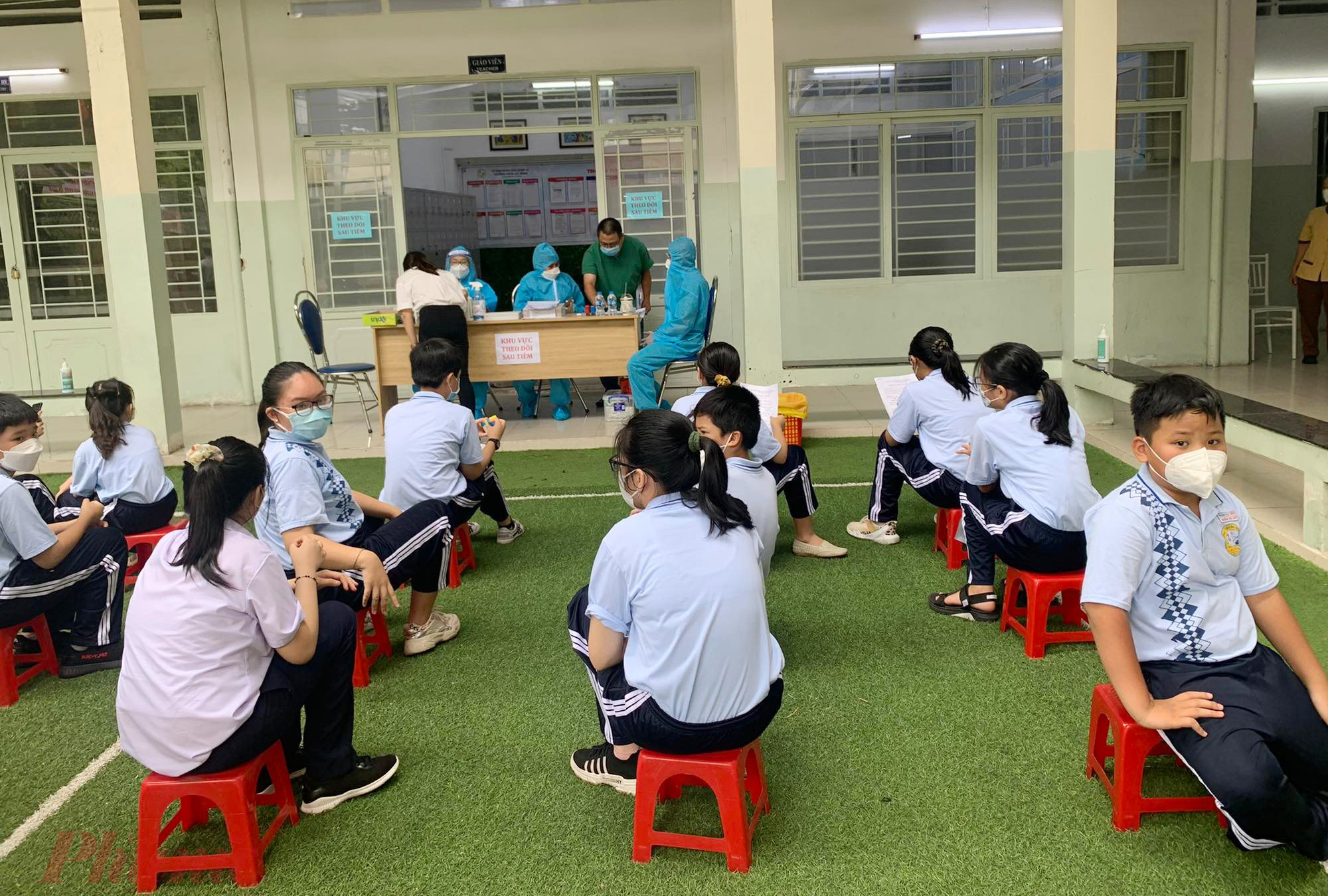 Học sinh lớp 6 trường THCS Lạc Hồng (quận 10) đang được các bác sĩ theo dõi sau tiêm tại trường