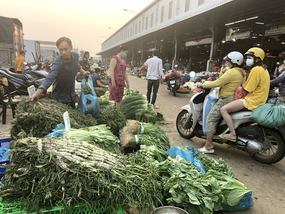 Thương nhân chợ đầu mối nông sản, thực phẩm Bình Điền bày bán hàng ở sân chợ - ẢNH: THANH HOA