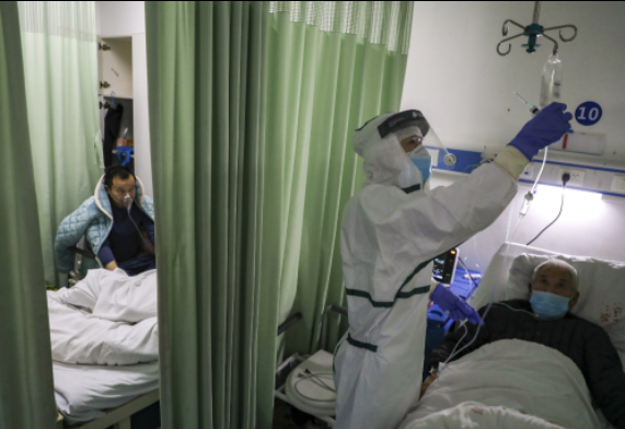 Một y tá kiểm tra một bệnh nhân trong khu cách ly Covid-19 ở thành phố Vũ Hán, tỉnh Hồ Bắc, Trung Quốc, trong những ngày đầu của đại dịch năm 2020. Ảnh: AP