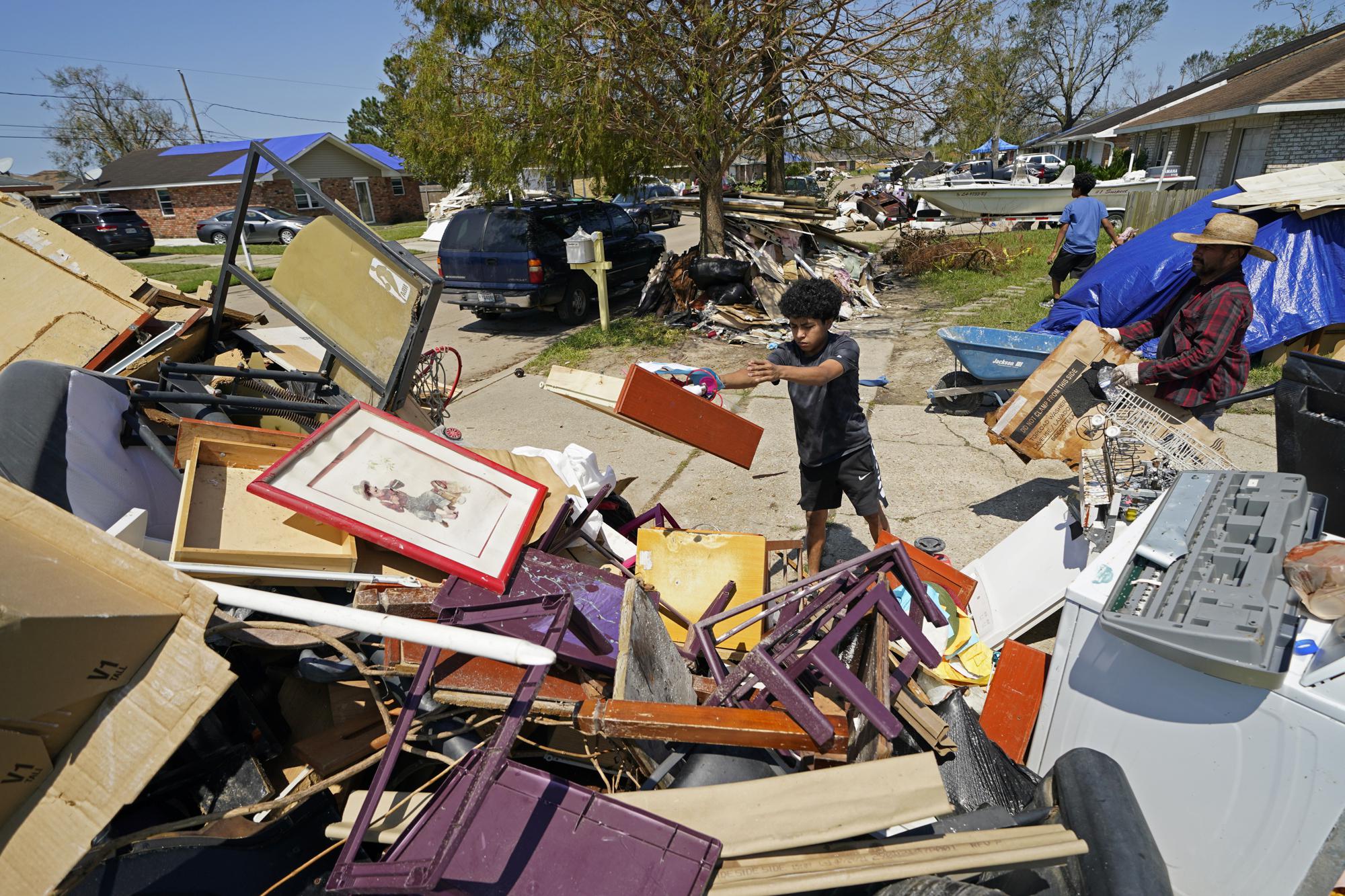 Samuael Hernandez, 15 tuổi, giúp cha mình - ông Antonio Hernandez - tháo dỡ ngôi nhà của họ bị ngập lụt sau cơn bão Ida ở LaPlace, Louisiana., ngày 9/9/2021