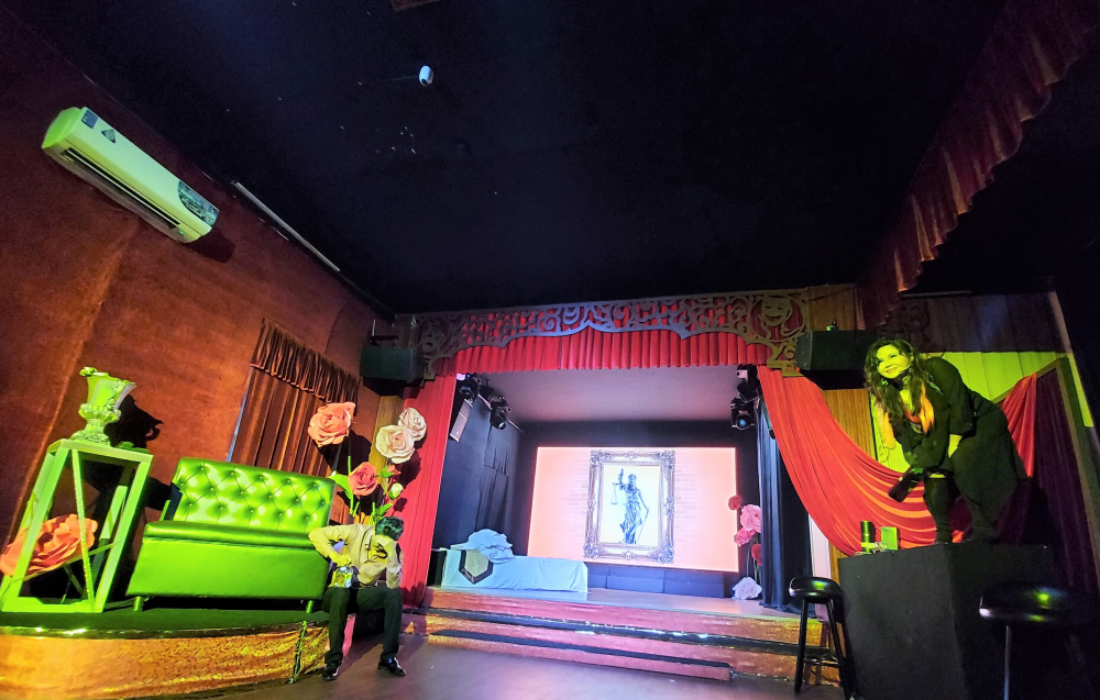 Bối cảnh sân khấu được thể hiện như một phòng khách sạn hạng sang.