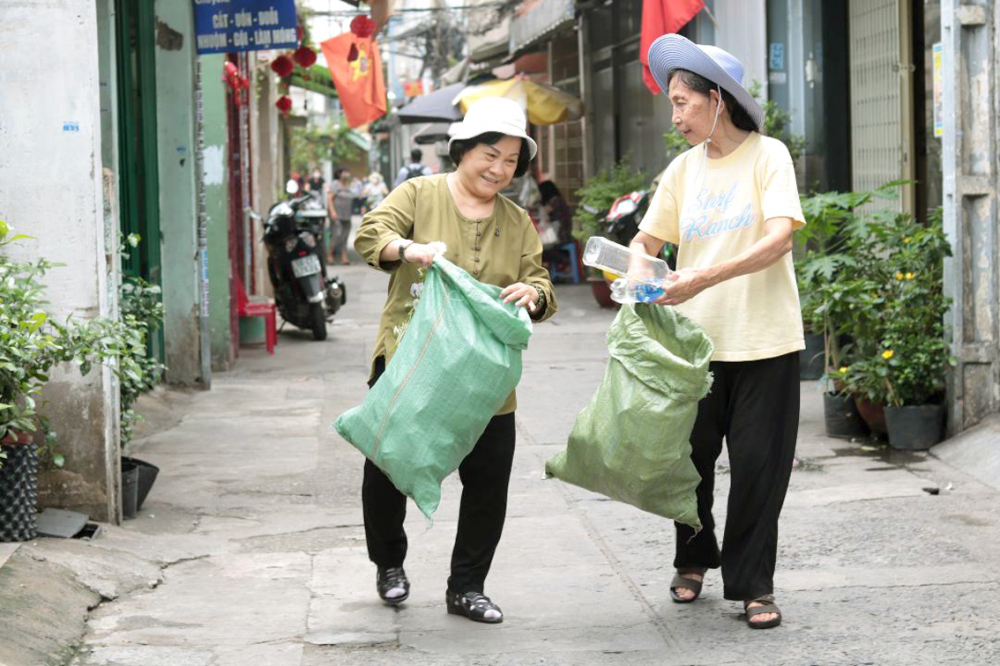  Hằng tuần, bà Cẩm (bên trái) và bà Điệp lại cùng nhau đi xin ve chai bán gây quỹ học bổng Nguyễn Thị Minh Khai