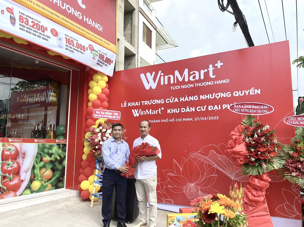Đại diện WinCommerce chúc mừng cửa anh Nguyễn Hoài Nam - chủ cửa hàng WinMart+ nhượng quyền đầu tiên tại TPHCM - Ảnh: Masan