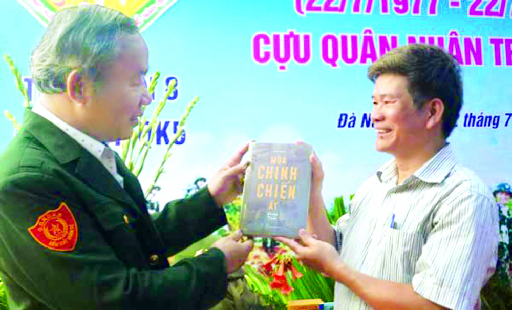 Nhà văn Đoàn Tuấn (phải) tặng tác phẩm Mùa chinh chiến ấy cho đồng đội tại Đà Nẵng vào năm 2017