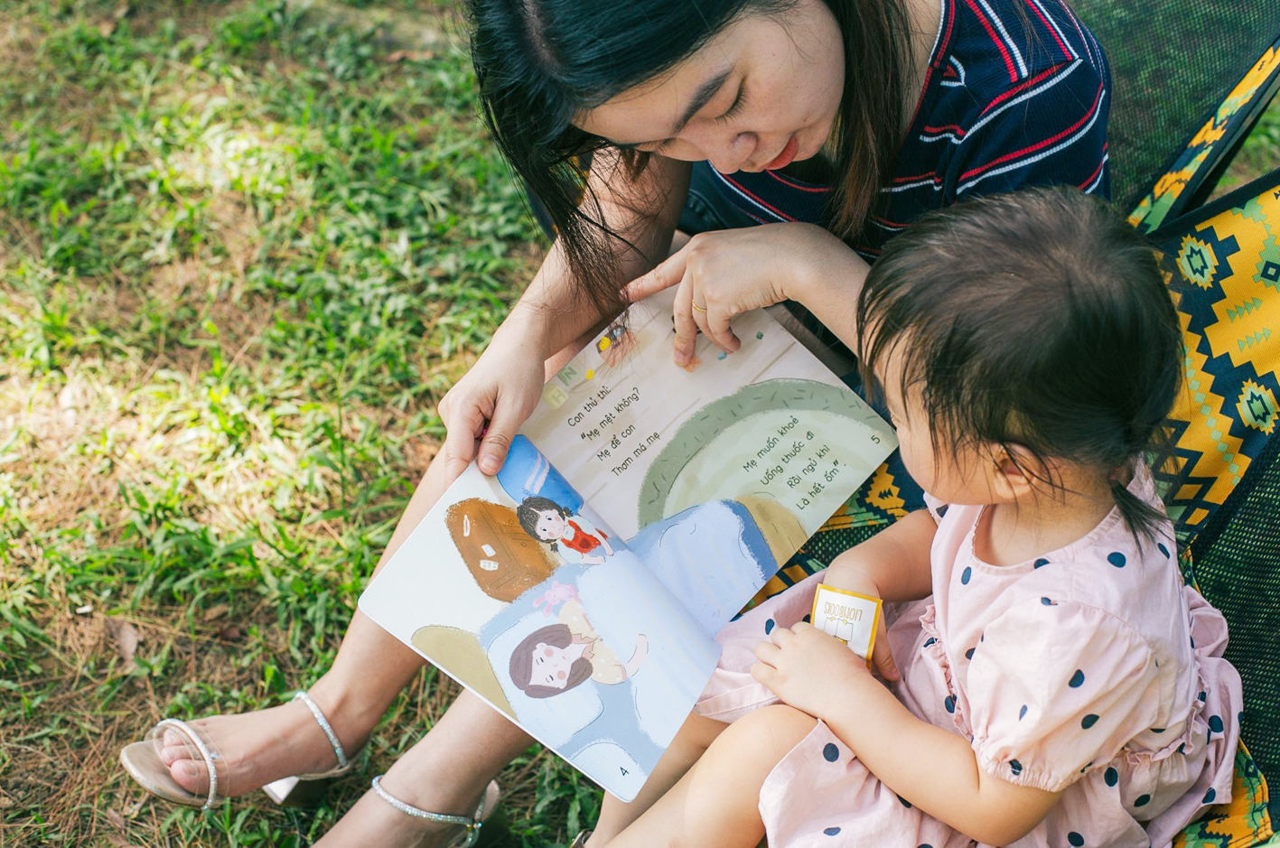 Tác giả Nguyễn Chiều Xuân và con gái - bé Nếp - bên những trang sách kể chuyện núi rừng