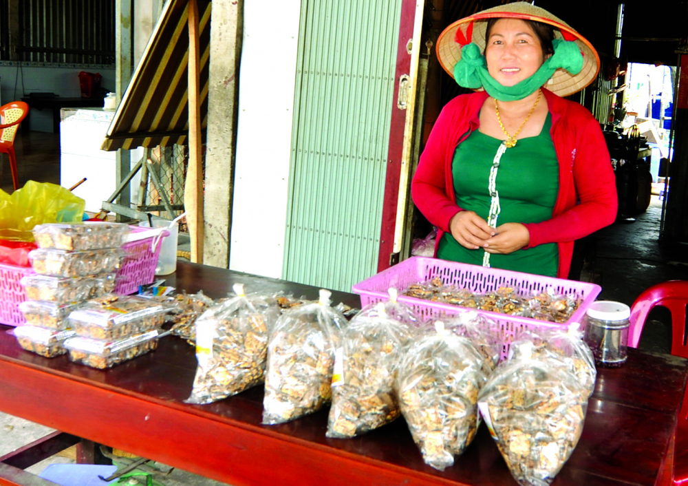 Chị Ngô Thị Hồng Nhung vừa làm vừa bán kẹo ngay trước nhà