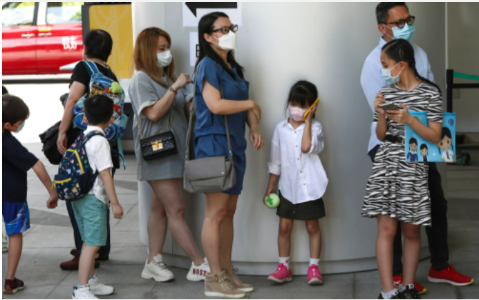 Cha mẹ và những người con của họ xếp hàng tại Bệnh viện Nhi đồng Hồng Kông ở Ngau Tau Kok. Ảnh: Jonathan Wong