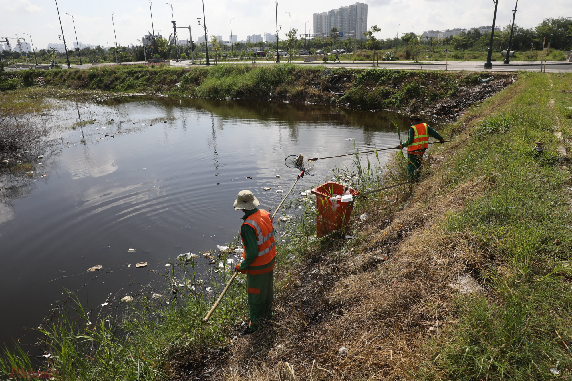 Nhiều khu vực rác ngập cả mặt hồ, công nhân vệ sinh phải dùng vợt vớt lên bờ.