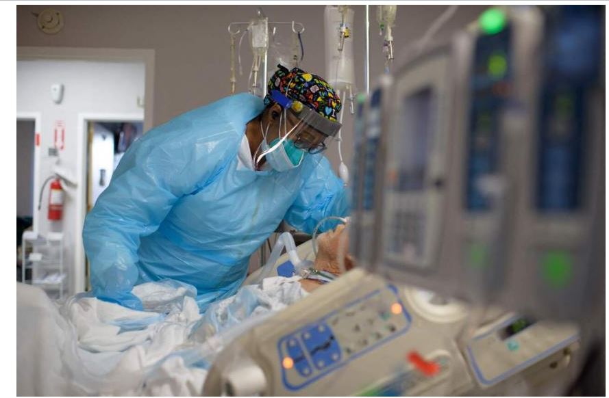Một nhân viên y tế an ủi một bệnh nhân trong khu Covid-19 tại Trung tâm Y tế United Memorial ở Texas, vào ngày 4 tháng 12 năm 2020.