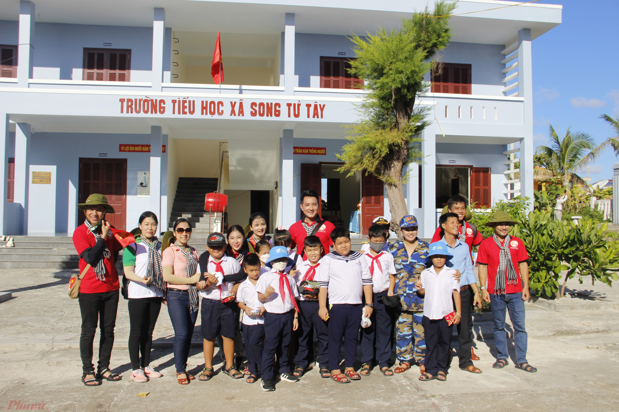 Ca sĩ Nguyễn Phi Hùng và các văn nghệ sĩ bên các em học sinh của Trường tiểu học Song Tử Tây.