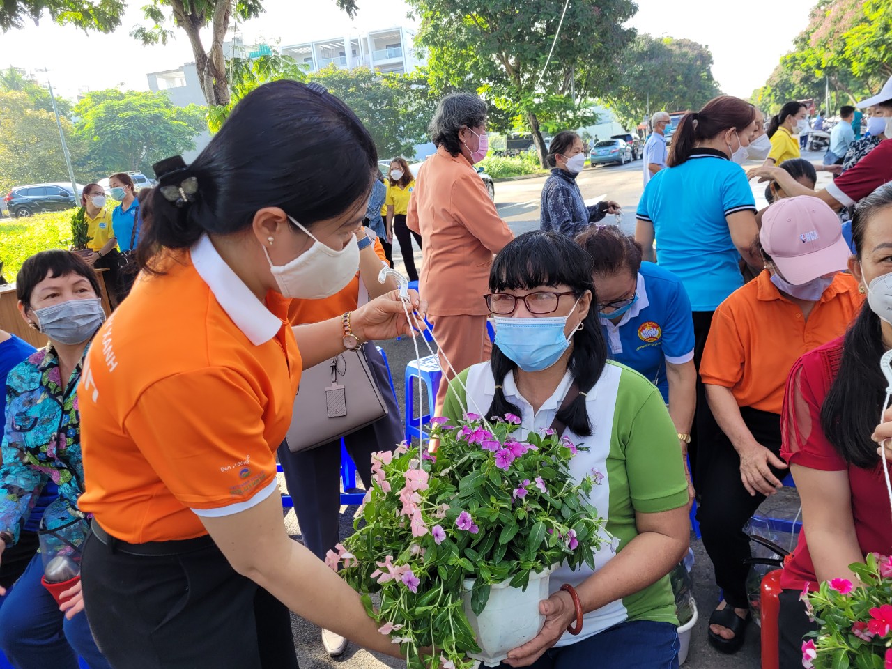 Bà Nguyễn Trần Phượng Trân - Chủ tịch Hội LHPN TP.HCM tặng hoa cho hội viên, phụ nữ  nhằm phát động các hộ gia đình tăng mảng xanh khu vực dân cư