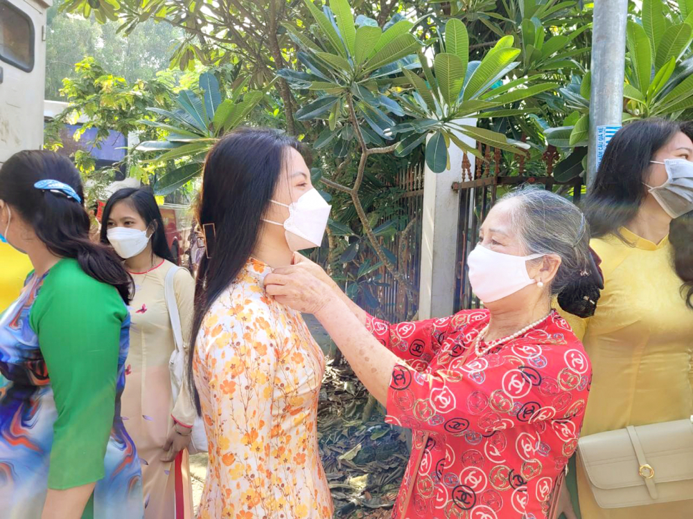 Bà Lê Thị Minh Huệ chăm chút trang phục cho “con gái” Soulita - một sinh viên Lào 