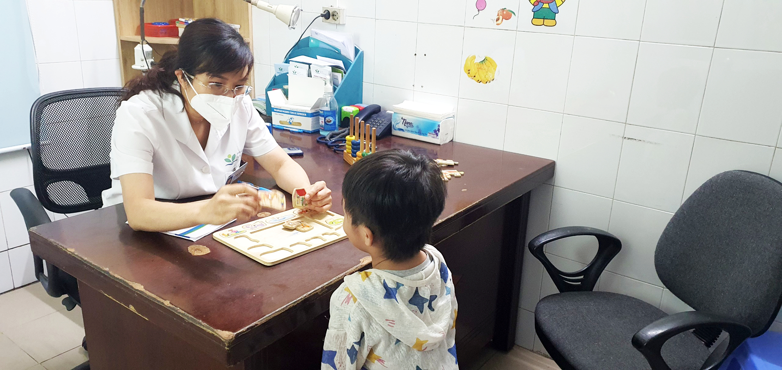 Bác sĩ khám ngôn ngữ cho trẻ tại Khoa Tâm thần Bệnh viện Nhi Trung ương - ẢNH: H.ANH