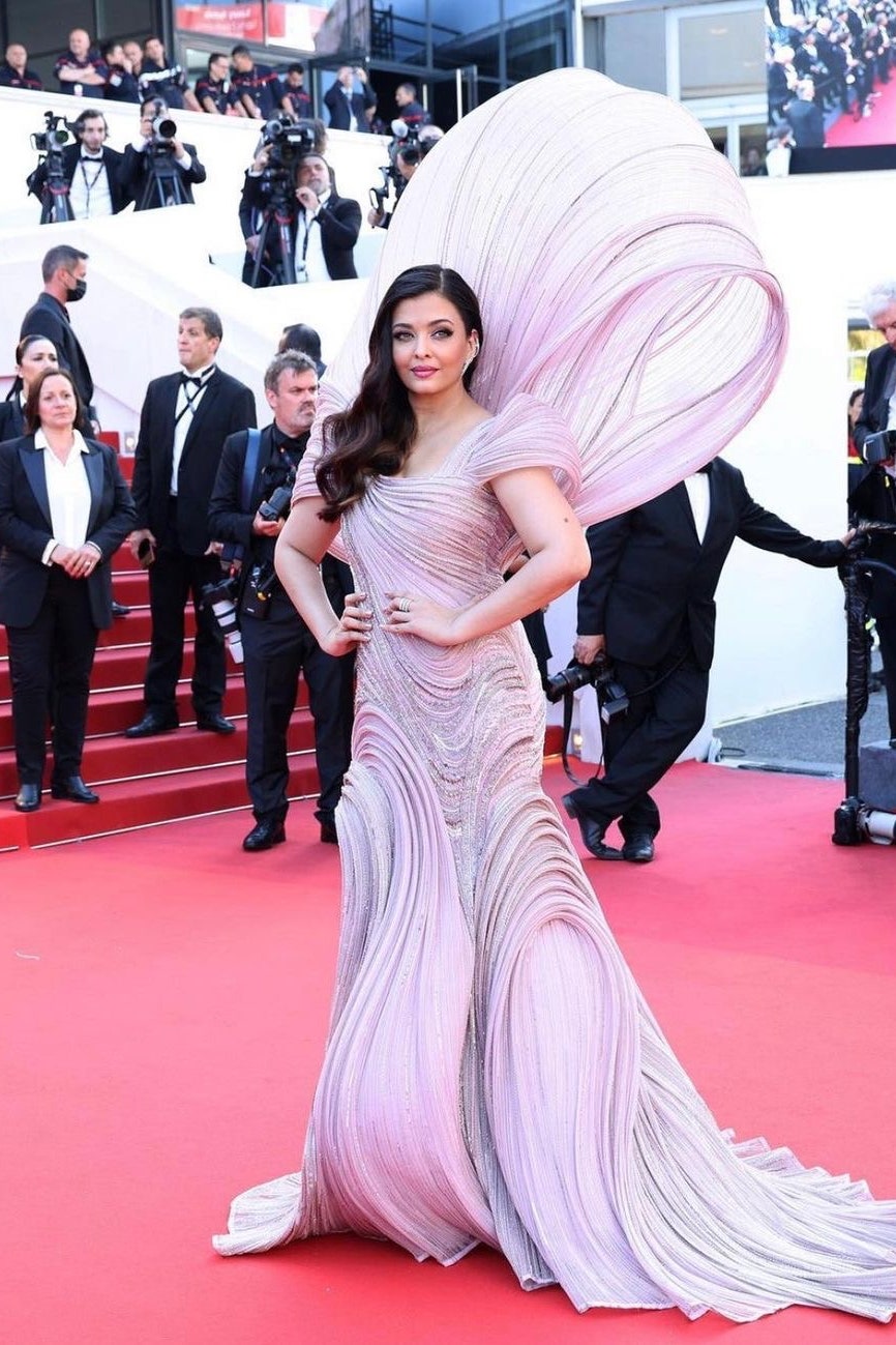 Hoa hậu Thế giới 1994 Aishwarya Rai là khách mời thường xuyên của Liên hoan phim Cannes. Trong ảnh, Aishwarya Rai diện đầm của Gaurav Gupta, với tên gọi Sự ra đời của thần Vệ Nữ. Bộ váy mất 3.500 giờ để hoàn thành, đính kết nhiều đá, pha lê, chi tiết thêu thủ công. Bộ váy được lấy cảm hứng từ bức tranh nổi tiếng của nghệ sĩ người Ý Botticelli.