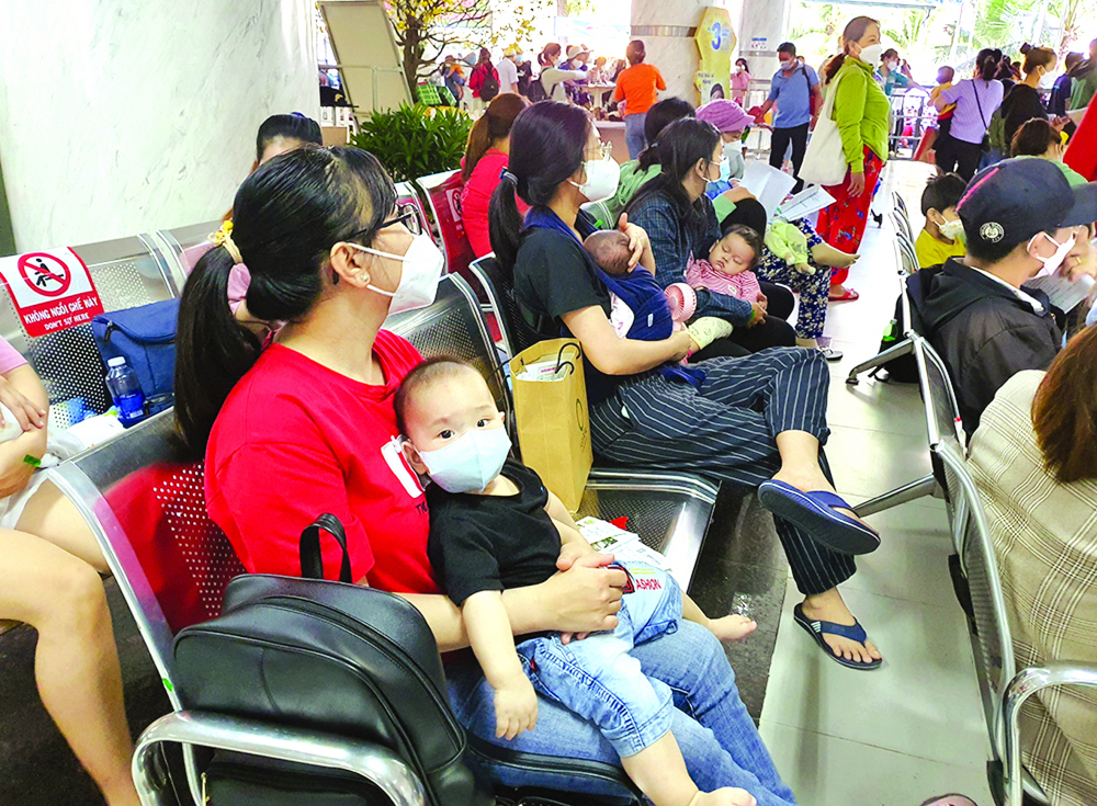Cha mẹ bệnh nhi sốt ruột chờ đến lượt khám cho trẻ tại Bệnh viện Nhi Đồng 2, TP.HCM ẢNH: PHẠM AN