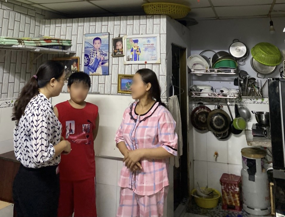 Bà Huỳnh Đặng Hà Tuyên (bìa trái) - Chủ tịch Hội LHPN quận Bình Tân - vô phòng trọ động viên gia đình chị V. Bé T.K có anh trai năm nay 10 tuổi
