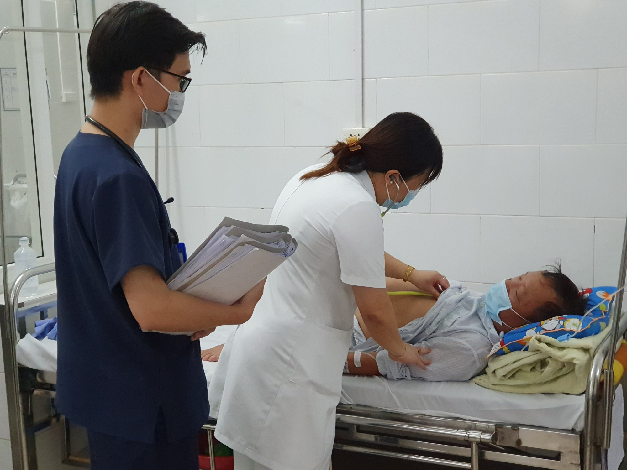 Các bác sĩ tại Trung tâm Bệnh nhiệt đới thăm khám bệnh cho bệnh nhân đang điều trị tại khoa