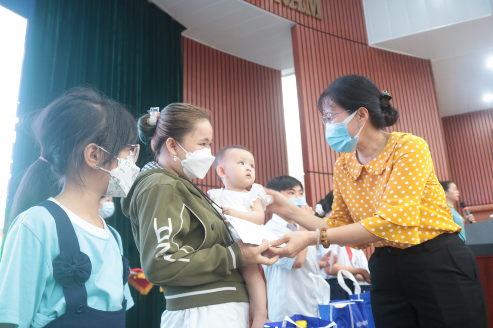 Bà Trương Nhựt Thẫm - Chủ tịch Hội LHPN quận 12 - trao tiền hỗ trợ cho các em. 