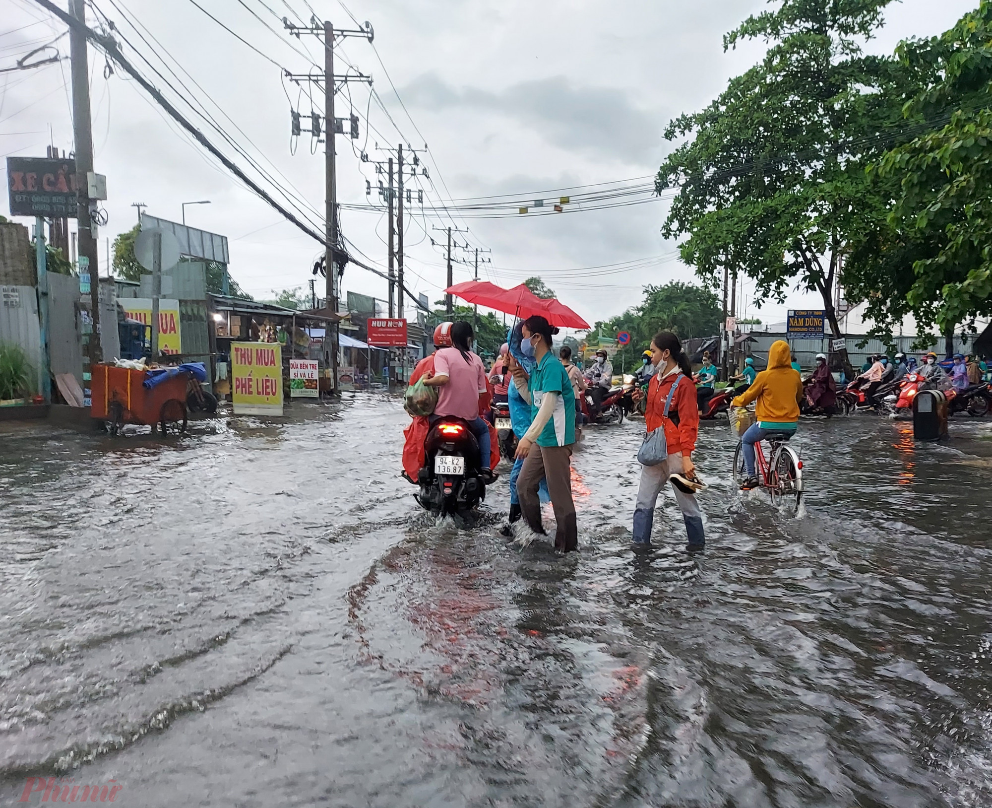 Công nhân của một công ty trên đường Hồ Học Lãm bì bõm lội nước về nhà sau cơn mưa chiều 2/6.