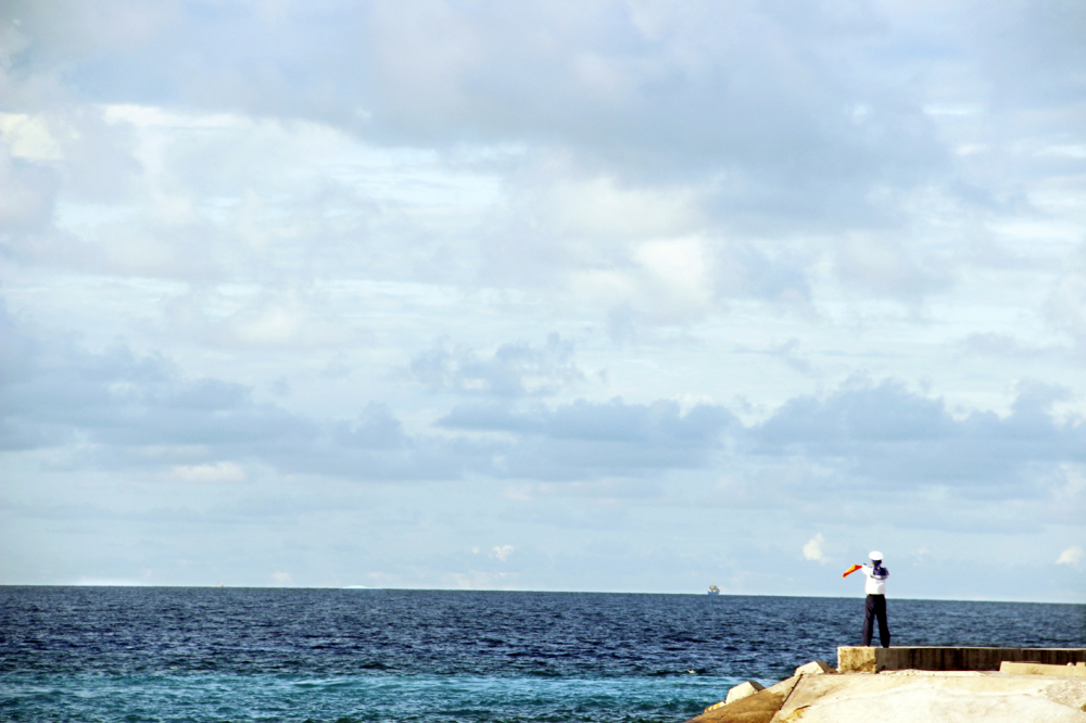 Chiến sĩ hải quân trên đảo Sinh Tồn đang hướng dẫn tàu cá vào neo đậu tại âu tàu của đảo - Ảnh: SƠN VINH
