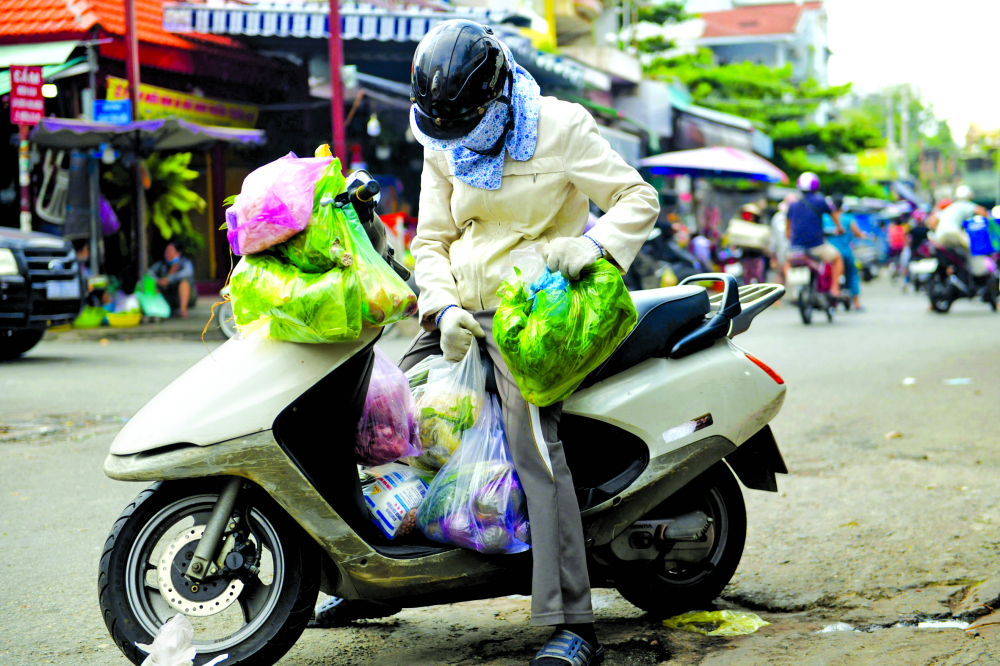 Một người dân đi chợ truyền thống ở TP.Thủ Đức sử dụng hàng chục túi ni-lông loại khó phân hủy để đựng hàng (ảnh chụp đầu tháng 6/2022) ẢNH: MINH AN